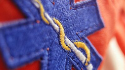 Close up of a fabric paramedic's badge showing a Caduceus staff.