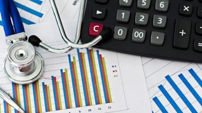 Stethoscope sitting on printed graph with calculator