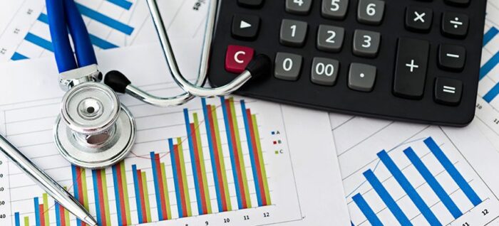 Stethoscope sitting on printed graph with calculator