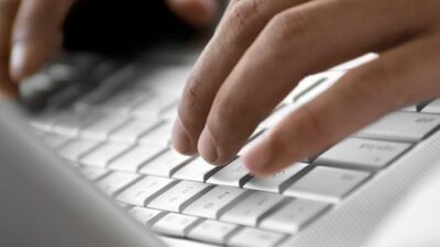 hands typing on laptop keyboard