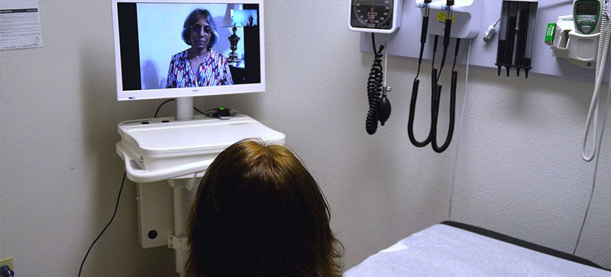 Doctor using videoconferencing for patient consultation
