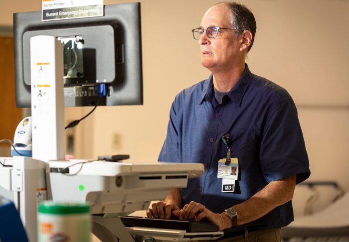 Dr. Ron Berrol using a computer to review a patient medical record.