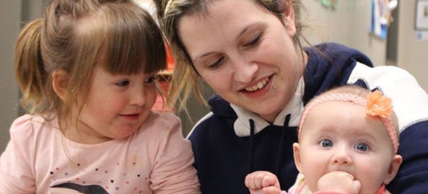 Mom holds her toddler and infant at the daycare center provided as part of her opioid treatment program