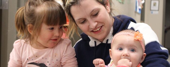 Mom holds her toddler and infant at the daycare center provided as part of her opioid treatment program