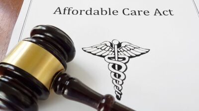 Paper copy of the Affordable Care Act with a gavel laying on top of it.