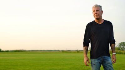 Anthony Bourdain standing in a field.