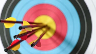 Dartboard with five arrows in the bullseye