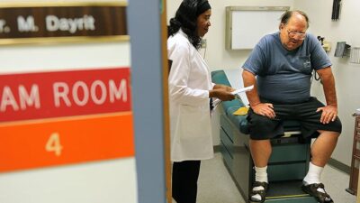 Patient Zig Fayant talks with Senior Physician Rita Ogbo during a consultation at the Herbert Humph. (Photo by Wally Skalij/Los Angeles Times via Getty Images)