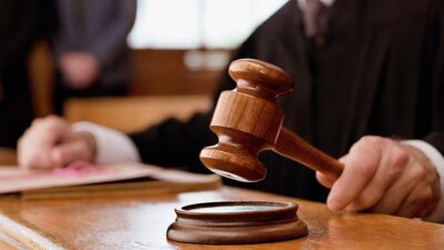 Judge holding a gavel in court room.