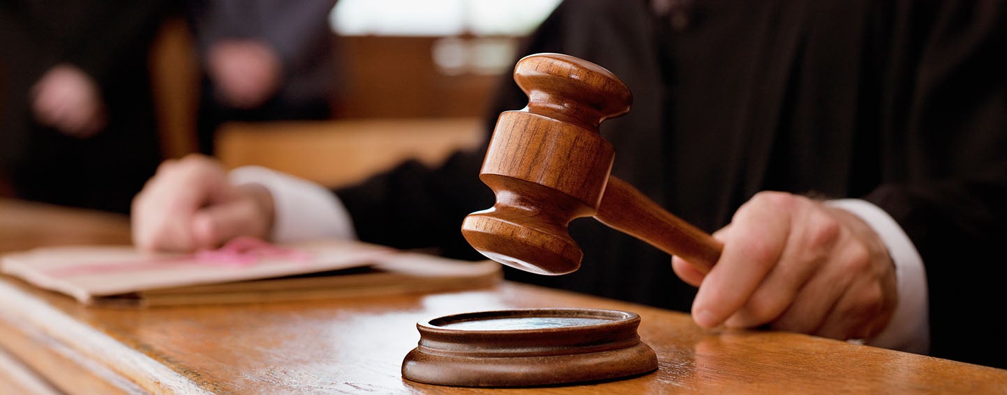 Judge holding a gavel in court room.