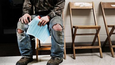 Man from rural area waits at remote area clinic for care.