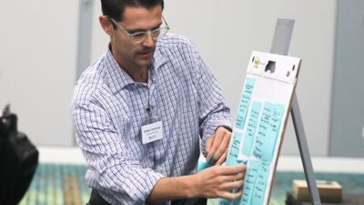 Participant at PRIMED Nashville event places notes on easel.