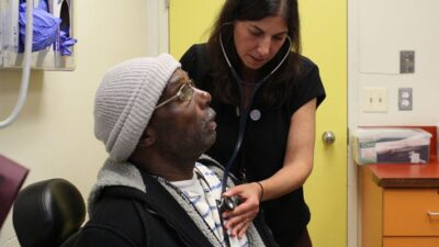 Doctor listens to patient's heart at transition clinic.