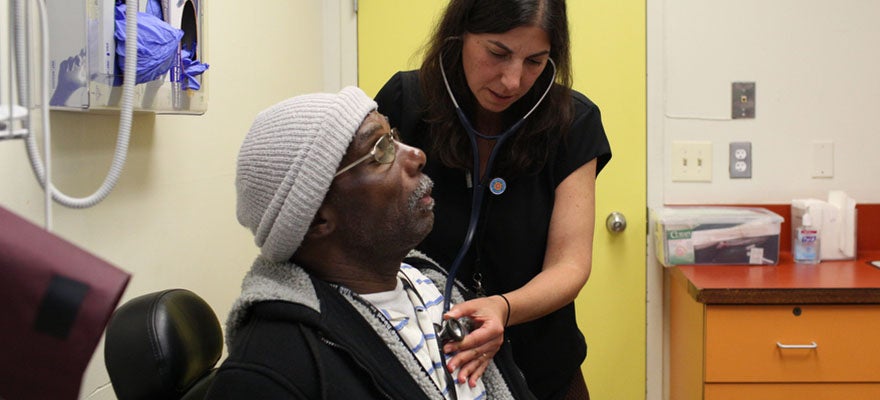 Doctor listens to patient's heart at transition clinic.