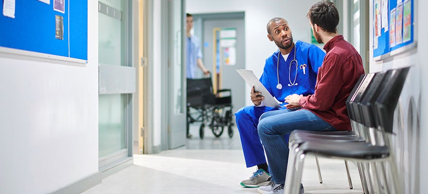 provider talking to patient in hallway.