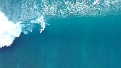 Aerial photo of surfer riding a big wave.