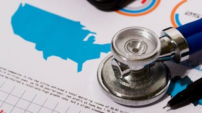 A stethoscope lays on a printed page containing a chart and a map of the United States