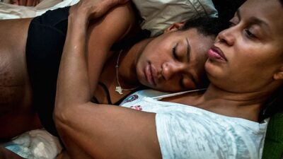Woman gives birth in a comforting and suportive environment with doula and family present.