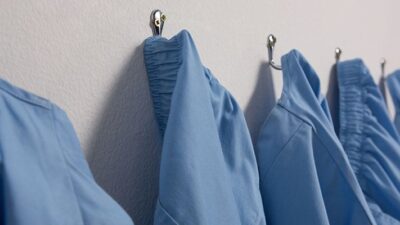 blue medical scrubs hanging on hooks
