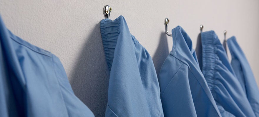 blue medical scrubs hanging on hooks