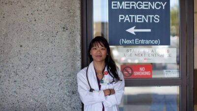 Dr. Renee Hsia stands in front of Emergency Room entrance sign.