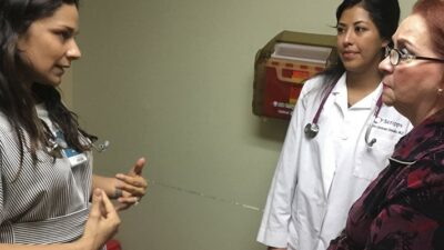 Dr. Karla Garcia, PRIME-LC graduate and attending family physician at San Ysidro Health in Chula Vista, a border city, talks to patient Gloria Lamadrid de Santana at a wellness visit, while first year resident Dr. Alondra Cardenas looks on. Garcia oversees and trains resident doctors, discussing their cases with them, and also has her own patients.