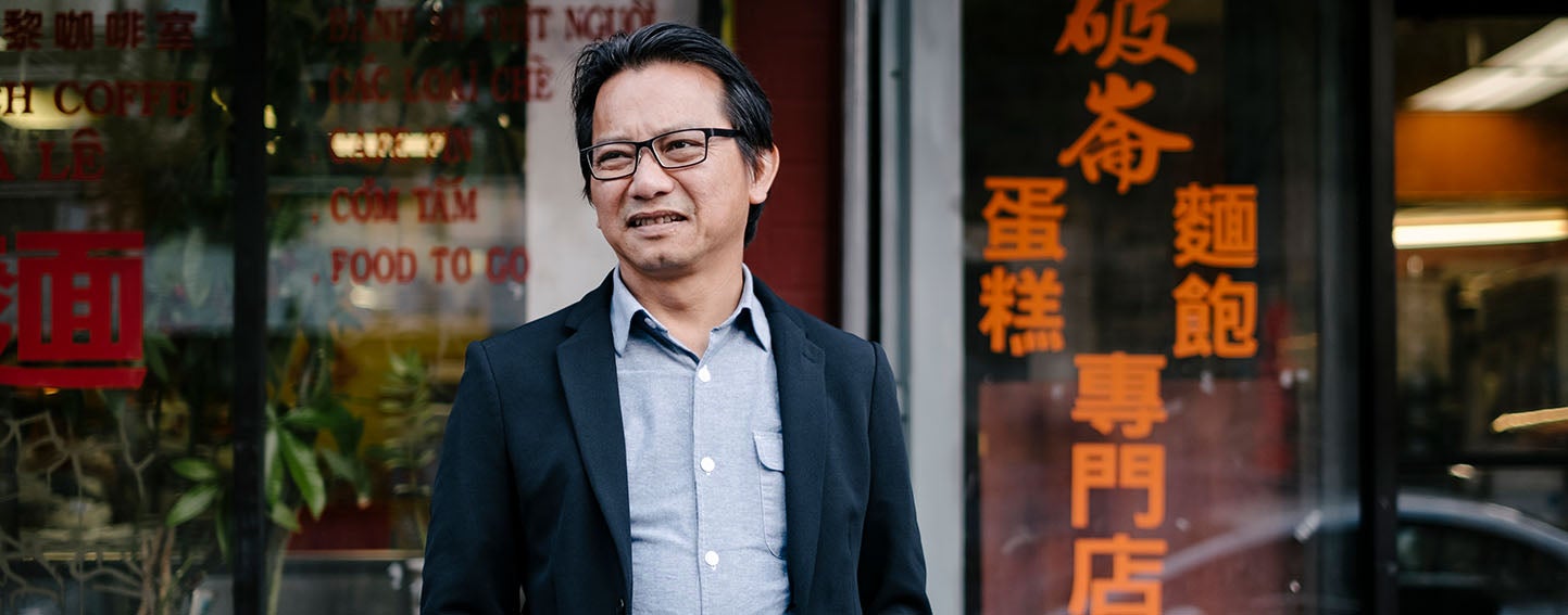 Sonny Le stands in front of a restaurant in downtown Oakland