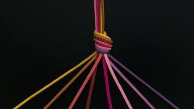 rainbow colored leather cords knotted to create a single strand