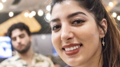 lose up-photo of latina woman in mid 20s with man in background