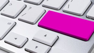 computer keyboard with a bright pink key