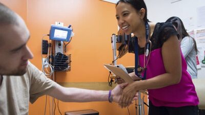 Medical practitioner shakes patient's hand.