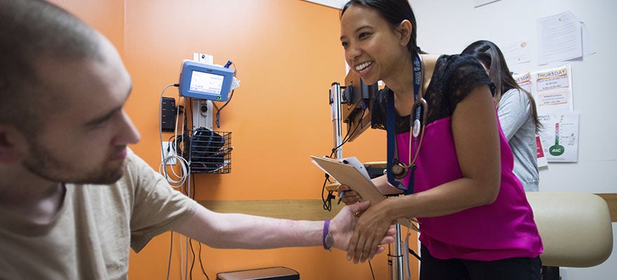 Medical practitioner shakes patient's hand.