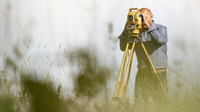 man surveying land at a distance