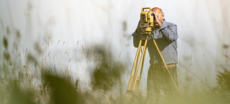 man surveying land at a distance