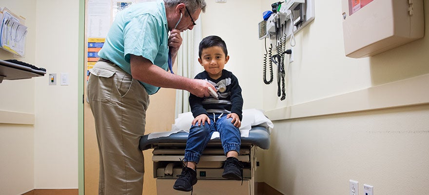 Young client is seen by medical practitioner at La Clinica, Oakland, CA.