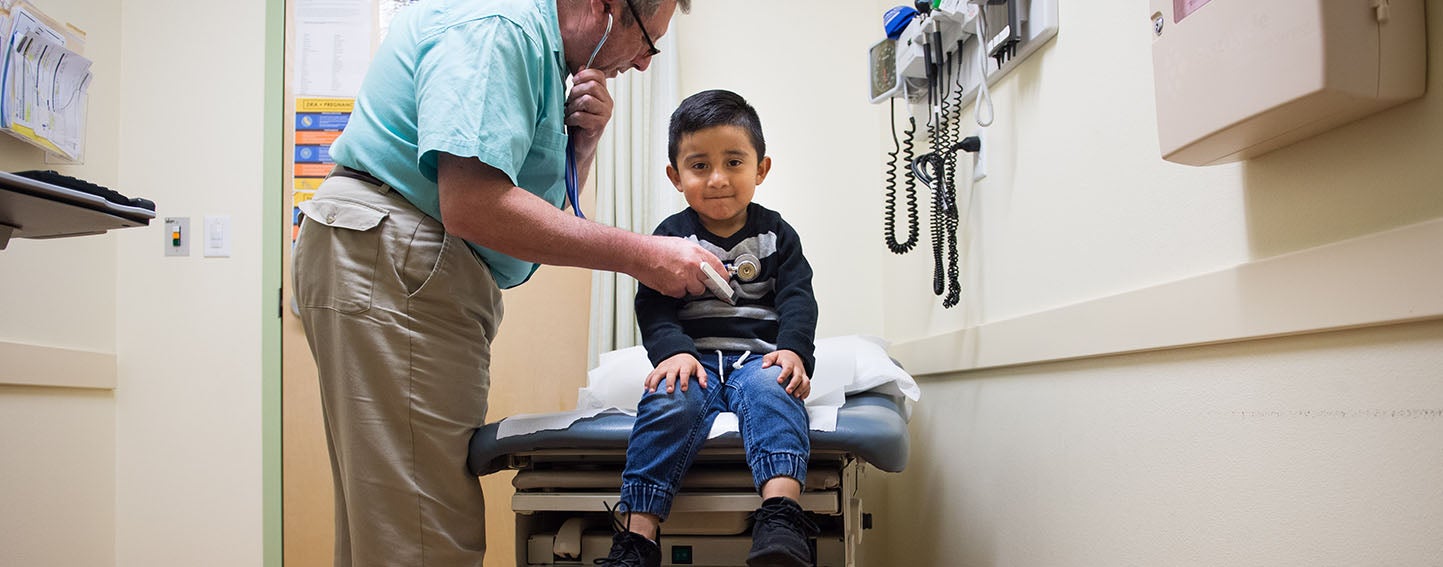 Young client is seen by medical practitioner at La Clinica, Oakland, CA.