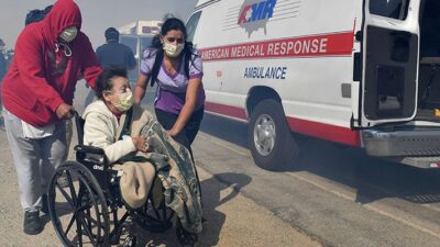 Elderly residents are evacuated from their care facility as flames and smoke approach