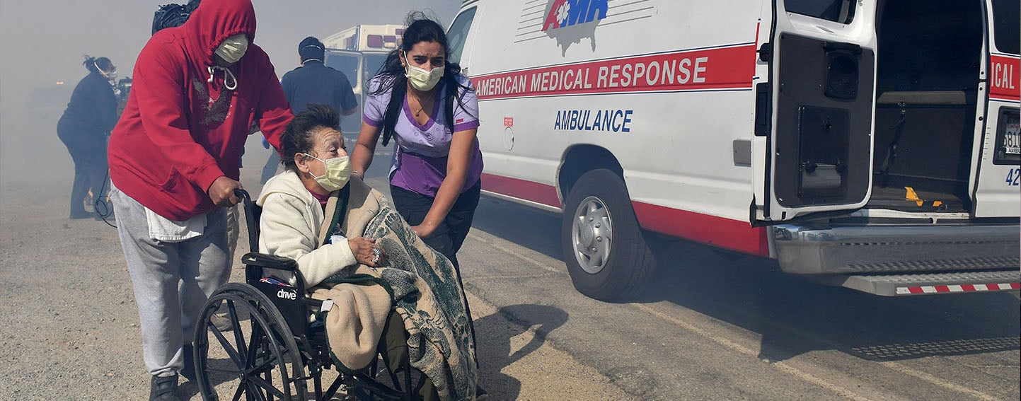 Elderly residents are evacuated from their care facility as flames and smoke approach