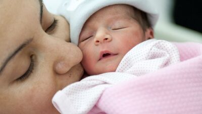 Mother snuggling newborn baby