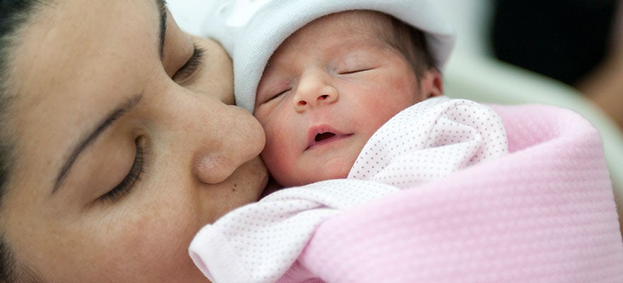 Mother snuggling newborn baby