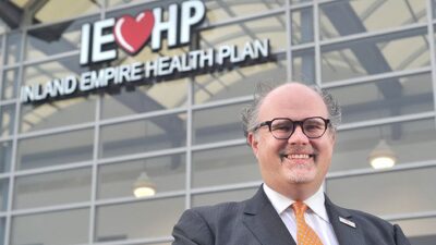 Jarrod McNaughgton standing in front of Inland Empire Health Plan building