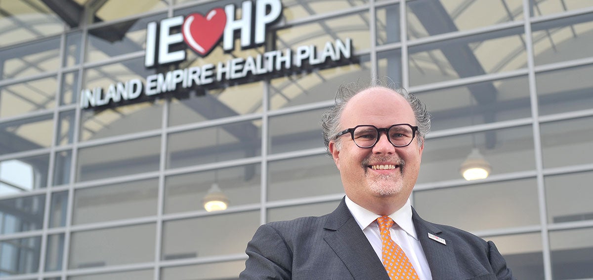 Jarrod McNaughton standing in front of Inland Empire Health Plan building