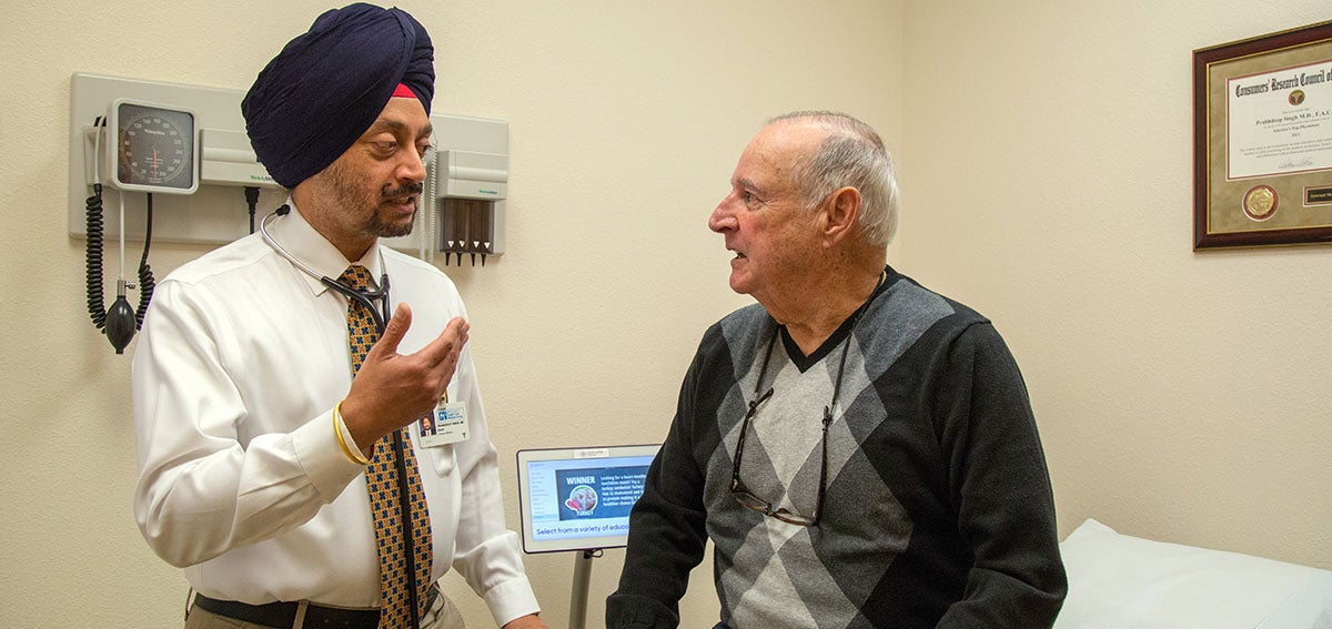 Prabhdeep Singh, MD, talks to patient in exam room