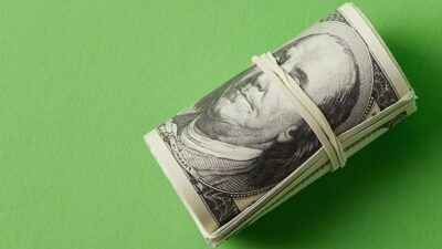 a roll of onehundred dollar bills secured with a rubber band
