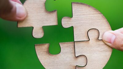 close up of hands assembling a circle shaped puzzle