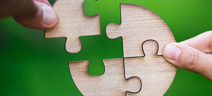 close up of hands assembling a circle shaped puzzle