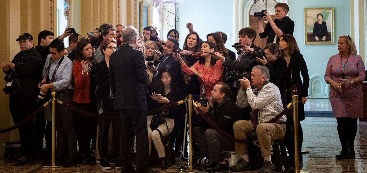 A senator talks with journalists in the US Capitol.