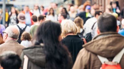 Crowd of people walking on a busy street.