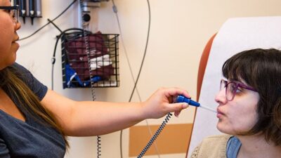 Patient having her temperature taken at a clinic.