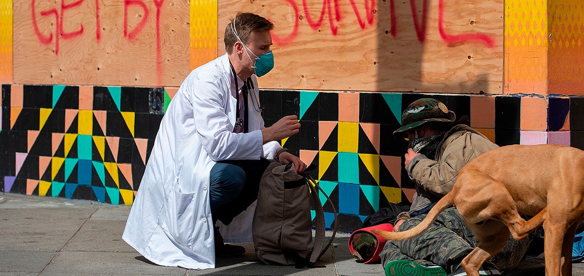 a doctor with the Haight Ashbury Free Clinic, speaks with person experiencing homelessness about the coronavirus